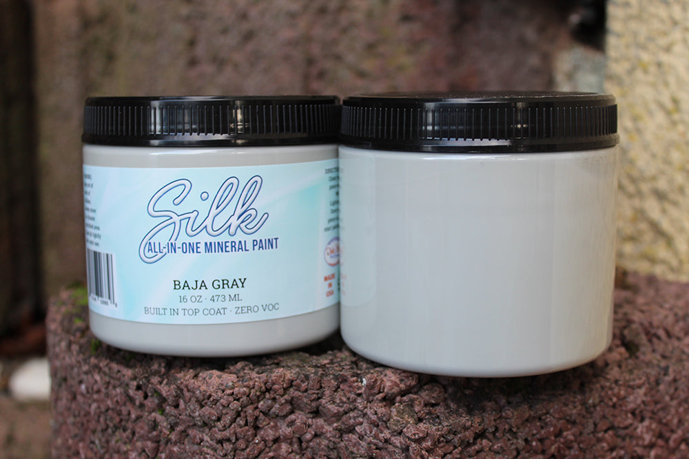 Peinture Silk de Dixie Belle. Couleur "Baja Gray" entre le blanc et le gris. Un équilibre apaisant entre deux neutres qui rehaussera une sensation de fraîcheur dans votre décor. La peinture Silk All-In-One est une peinture crémeuse et auto nivelante en une seule étape. Il a un bloqueur de taches intégré (à base d'eau), un apprêt et une couche de finition. Résistante à la moisissure. Vous pouvez utiliser cette peinture à l'intérieur car elle est inodore et non toxique.