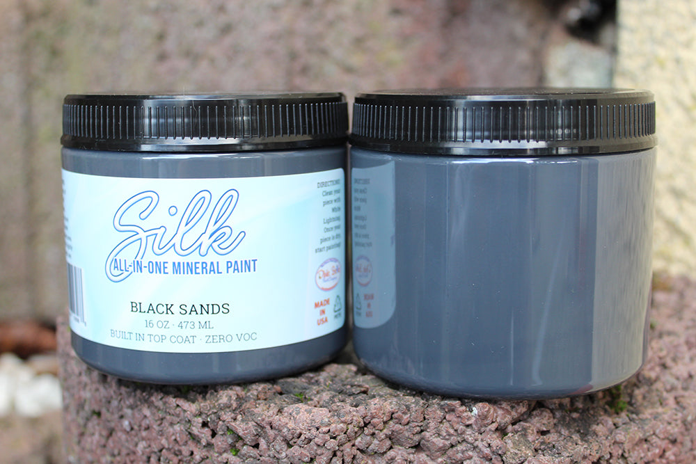 Peinture Silk de Dixie Belle. Couleur "Black Sands". Cette couleur de peinture sombre ne peut pas être manquée ! Black Sands crée un look gris-noir assombri sur vos projets de bricolage ! La peinture Silk All-In-One est une peinture crémeuse et auto nivelante en une seule étape. Il a un bloqueur de taches intégré (à base d'eau), un apprêt et une couche de finition. Résistante à la moisissure. Vous pouvez utiliser cette peinture à l'intérieur car elle est inodore et non toxique.