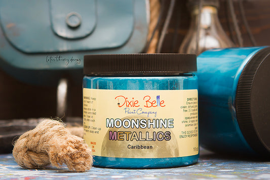 Peinture Moonshine Metallics de Dixie Belle. Couleur "Caribbean" bleue. La peinture minérale à la craie métallique Moonshine est une peinture métallique riche et brillante en une seule étape avec de beaux pigments. Utilisez cette couleur sur Antebellum Blue ou Dixie Belle Blue pour un peu de charme côtier.